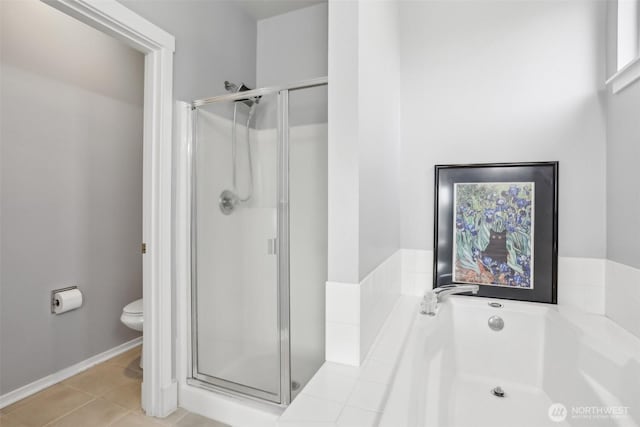 bathroom with a shower stall, tile patterned floors, a garden tub, and toilet