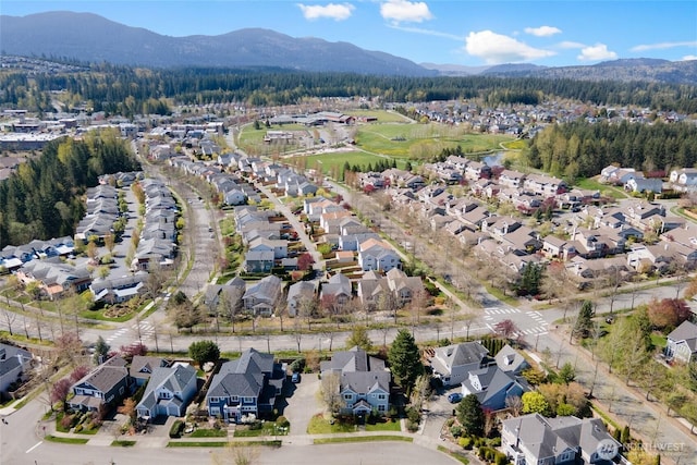aerial view featuring a view of trees, a mountain view, and a residential view