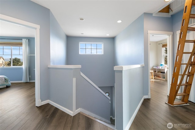 hallway with baseboards, dark wood-style flooring, an upstairs landing, and recessed lighting