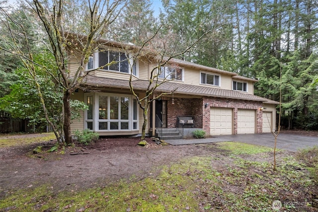 view of front of house featuring aphalt driveway, a porch, brick siding, and a garage