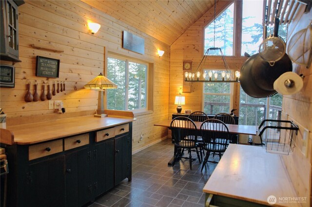 863 Chinook Way, Anacortes, WA 98221 - dining room featuring high vaulted ceiling, stone finish flooring, wood walls, wooden ceiling, and a chandelier
