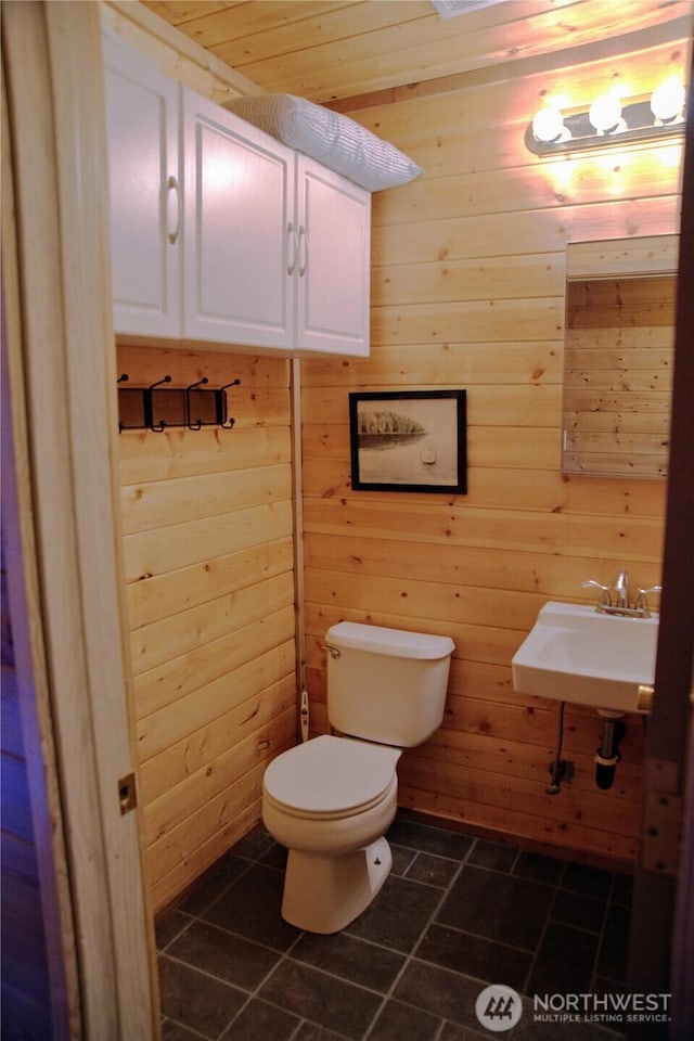 863 Chinook Way, Anacortes, WA 98221 - half bath featuring a sink, toilet, wood walls, and tile patterned flooring