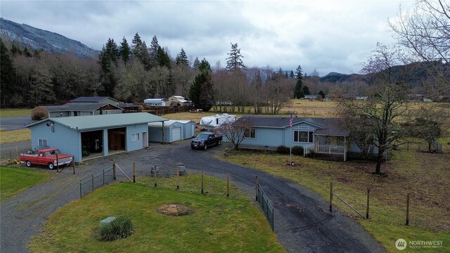 136 Mule Dr, Glenoma, WA 98336 - view of front of property with a front lawn, fence, dirt driveway, an outbuilding, and a mountain view