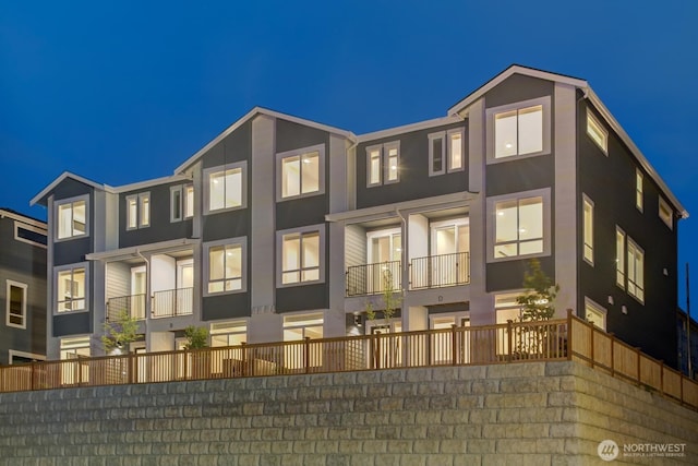 back of house at night featuring stucco siding