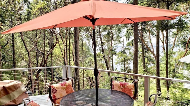 wooden deck featuring a grill and outdoor dining area