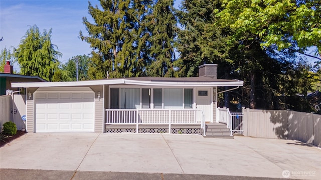 view of front of home featuring a chimney, a porch, an attached garage, concrete driveway, and fence