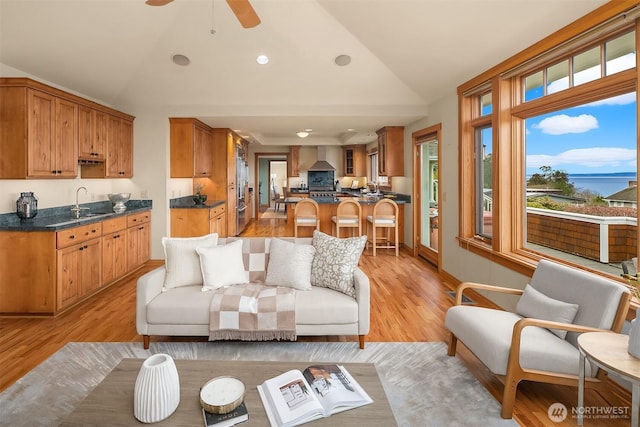 living room with light wood finished floors, a ceiling fan, lofted ceiling, and recessed lighting