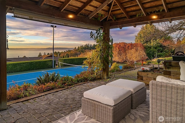 view of patio with a water view, a gazebo, and a tennis court