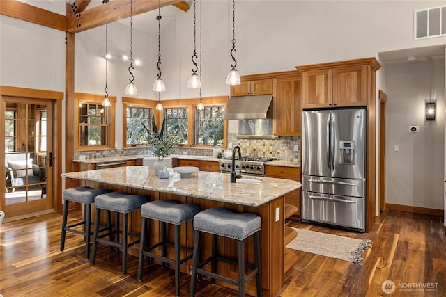 121 Hard Scrabble Ln, Cle Elum, WA 98922 - kitchen featuring stainless steel fridge with ice dispenser, under cabinet range hood, high vaulted ceiling, a kitchen island with sink, and brown cabinets