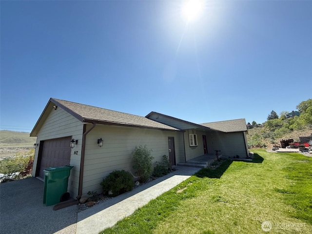 single story home with an attached garage, driveway, and a front yard