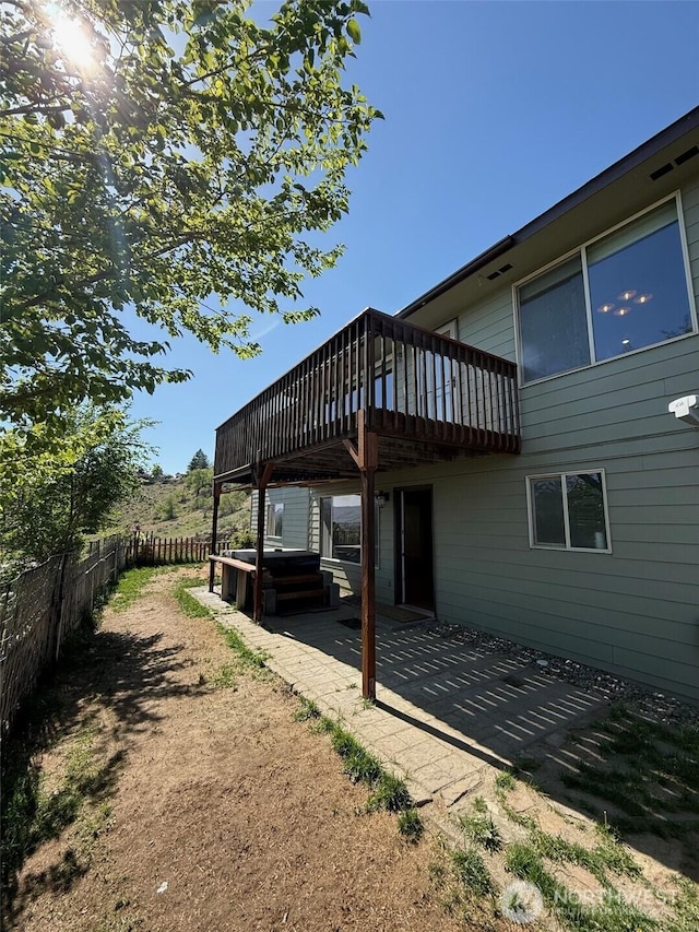 exterior space with a patio area, a jacuzzi, fence, and a deck