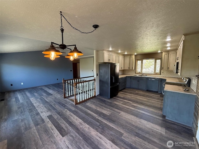 kitchen with a sink, appliances with stainless steel finishes, dark wood-style floors, and a textured ceiling