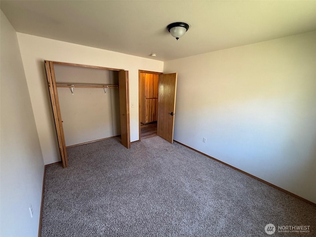 unfurnished bedroom with carpet flooring, baseboards, and a closet