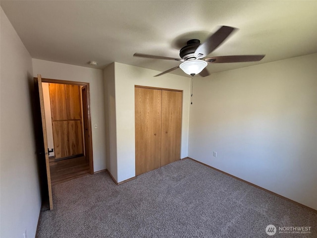 unfurnished bedroom featuring a closet, baseboards, ceiling fan, and carpet flooring