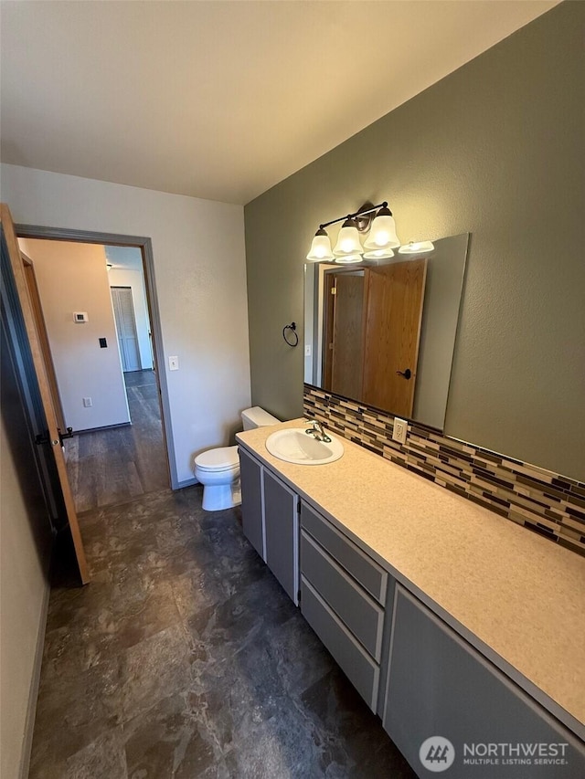 bathroom featuring vanity, decorative backsplash, and toilet
