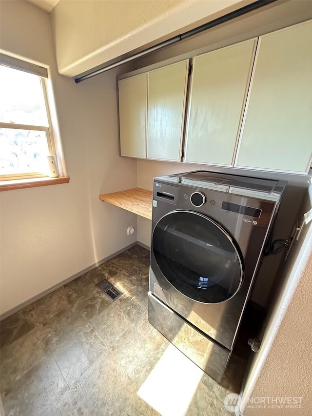 clothes washing area featuring cabinet space, baseboards, washer / dryer, and visible vents