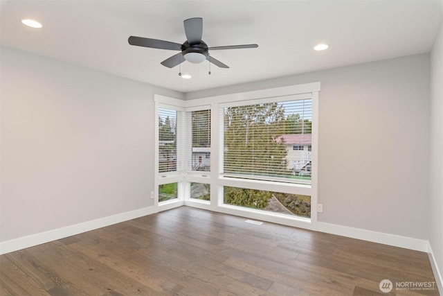 spare room featuring baseboards, recessed lighting, and wood finished floors
