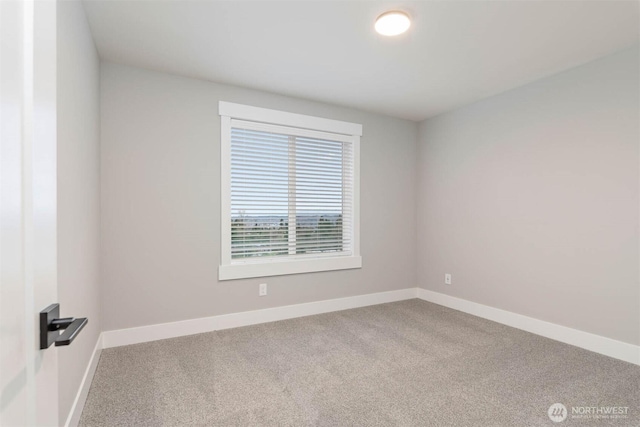 carpeted spare room with baseboards