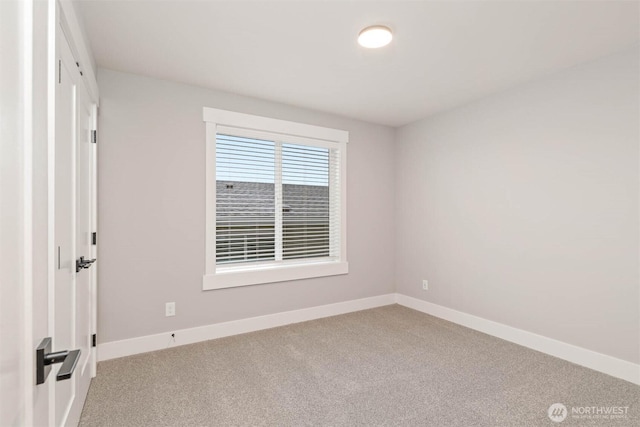 spare room with baseboards and carpet