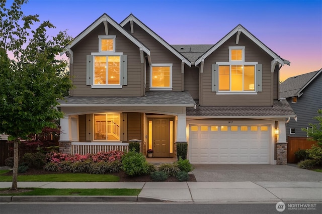 1497 Elk Run Pl SE, North Bend, WA 98045 - craftsman-style house featuring covered porch, concrete driveway, a shingled roof, a garage, and stone siding