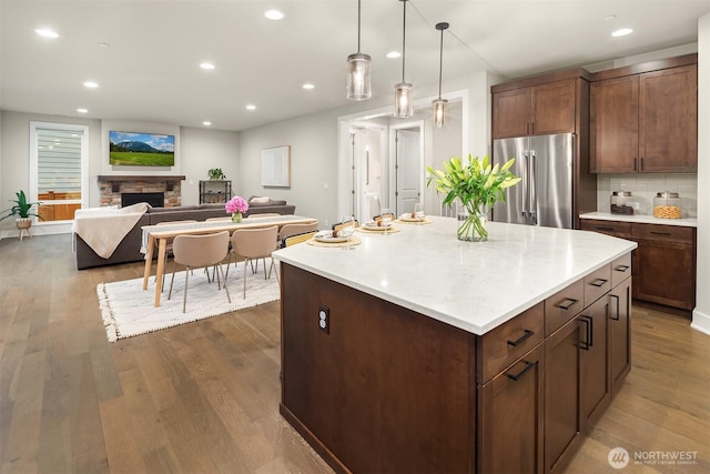 1497 Elk Run Pl SE, North Bend, WA 98045 - kitchen featuring high end refrigerator, dark wood finished floors, recessed lighting, a center island, and a fireplace