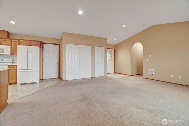 1529 Thompson Dr, Camano Island, WA 98282 - unfurnished living room featuring light carpet, visible vents, arched walkways, and lofted ceiling