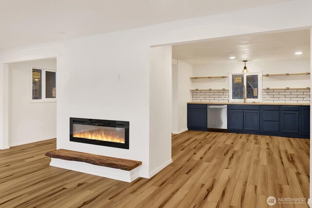 13574 S Green St, Anacortes, WA 98221 - interior space with light wood finished floors, tasteful backsplash, stainless steel dishwasher, and a glass covered fireplace
