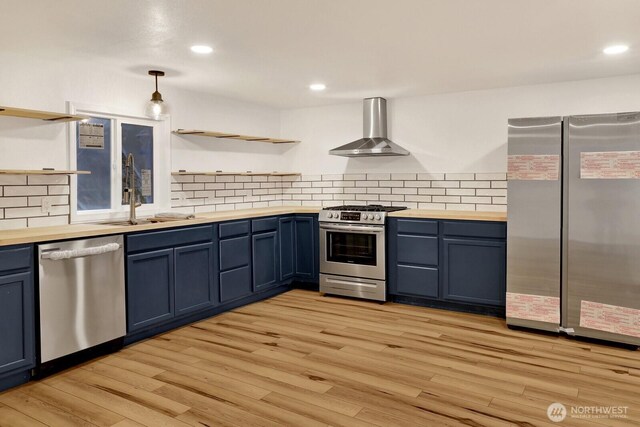 13574 S Green St, Anacortes, WA 98221 - kitchen with stainless steel appliances, wooden counters, blue cabinetry, and wall chimney range hood