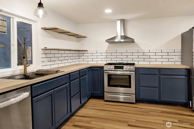 13574 S Green St, Anacortes, WA 98221 - kitchen featuring wall chimney range hood, wooden counters, appliances with stainless steel finishes, and open shelves