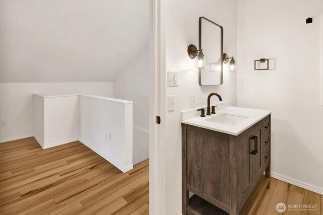 13574 S Green St, Anacortes, WA 98221 - bathroom with lofted ceiling, vanity, baseboards, and wood finished floors