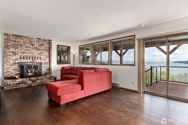 living room with a baseboard heating unit, plenty of natural light, a textured ceiling, and hardwood / wood-style floors