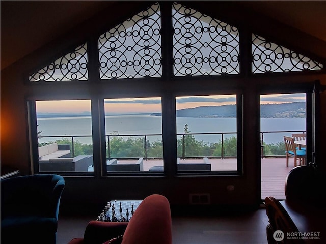living room featuring visible vents, high vaulted ceiling, and a water view