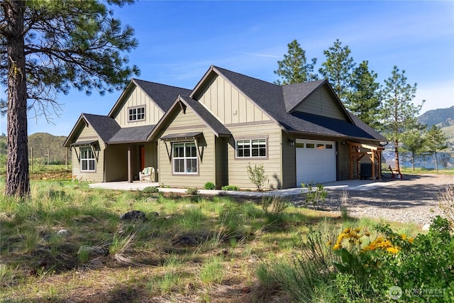 craftsman inspired home featuring roof with shingles, board and batten siding, an attached garage, a mountain view, and driveway