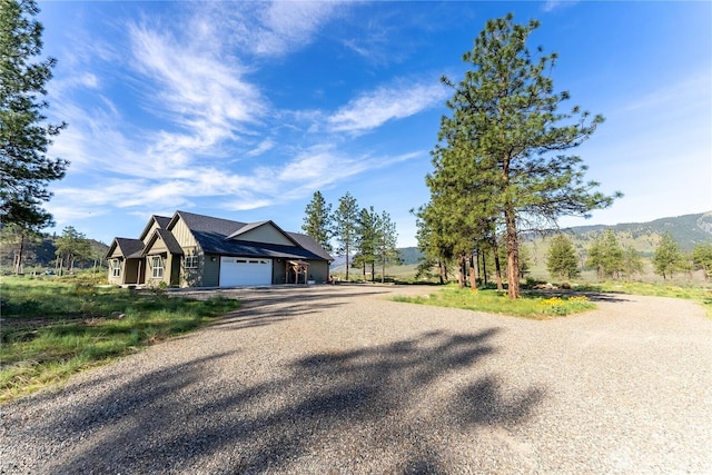 view of front of house with a garage, a mountain view, and driveway