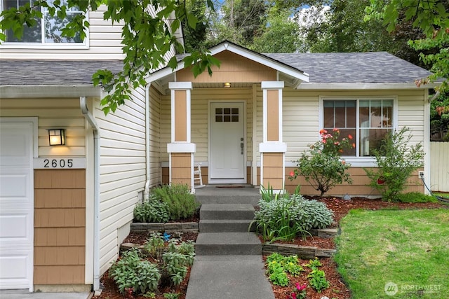 doorway to property with a shingled roof and a garage
