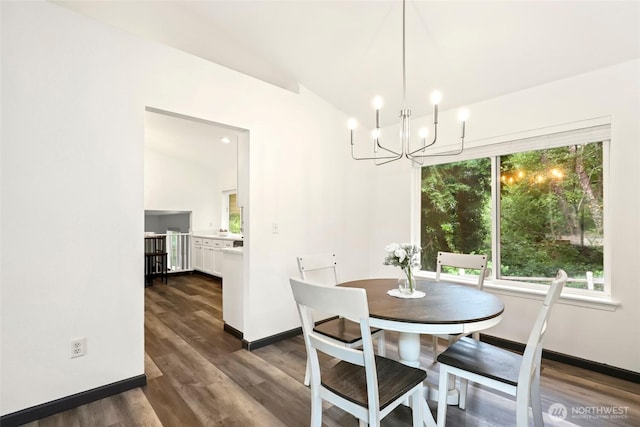 dining space with baseboards, a notable chandelier, lofted ceiling, and dark wood-type flooring