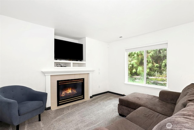 carpeted living area featuring baseboards and a fireplace