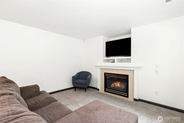 carpeted living room with baseboards and a tiled fireplace