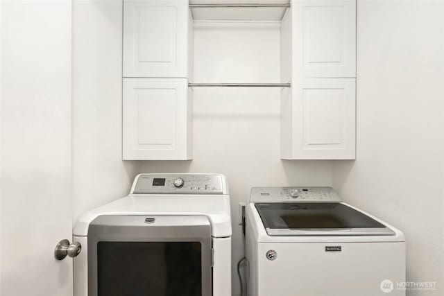 laundry room featuring washer and clothes dryer and cabinet space