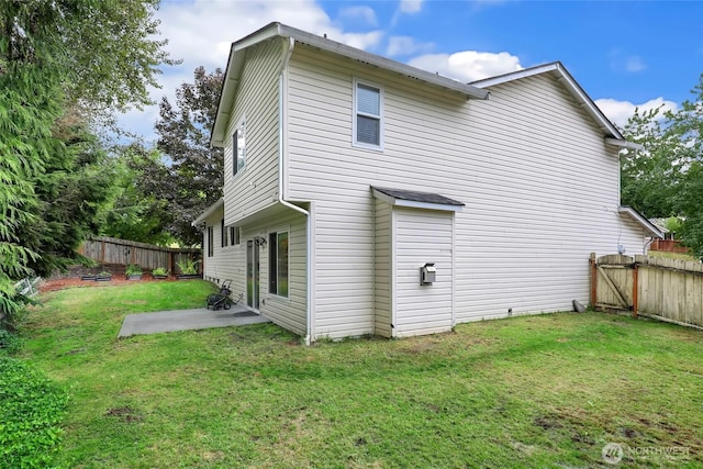 back of house featuring a fenced backyard, a yard, and a patio area