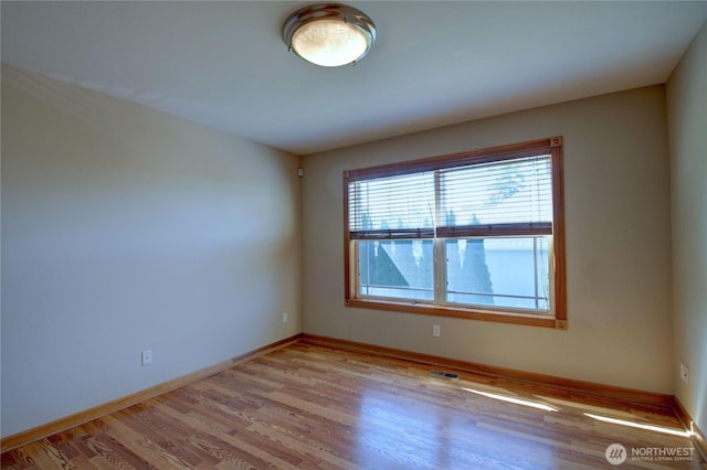 unfurnished room with baseboards, visible vents, and light wood finished floors