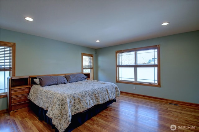 bedroom with recessed lighting, wood finished floors, visible vents, and baseboards