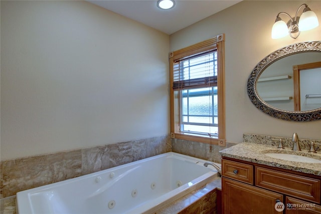 full bathroom with recessed lighting, a jetted tub, and vanity