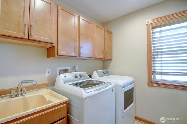 laundry area featuring cabinet space, a wealth of natural light, a sink, and separate washer and dryer