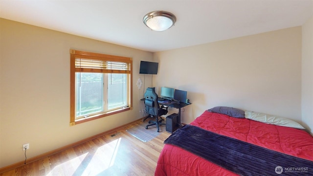bedroom with baseboards and wood finished floors