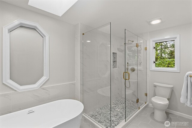 4381 239th Pl SE, Sammamish, WA 98029 - full bath featuring toilet, a freestanding tub, a skylight, tile patterned flooring, and a shower stall