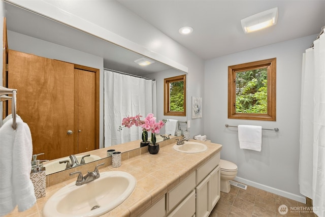 4381 239th Pl SE, Sammamish, WA 98029 - full bathroom with baseboards, plenty of natural light, double vanity, toilet, and recessed lighting