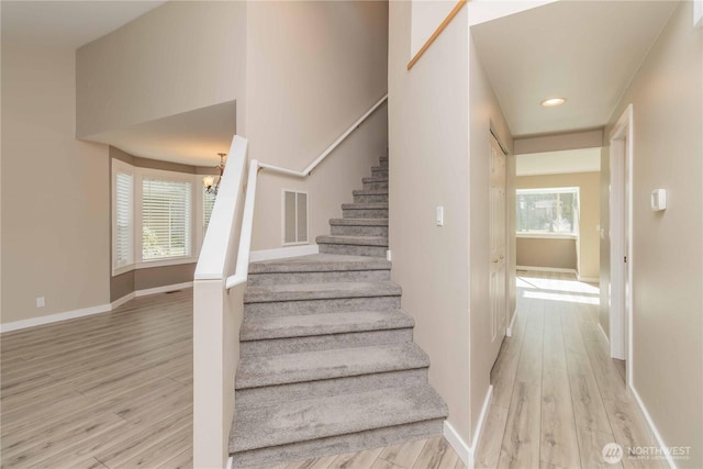 staircase featuring visible vents, baseboards, and wood finished floors