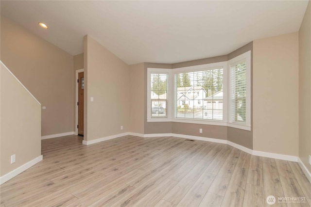unfurnished room with baseboards, light wood finished floors, and recessed lighting