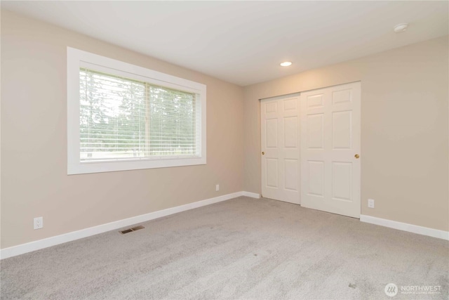 unfurnished bedroom featuring a closet, carpet flooring, baseboards, visible vents, and recessed lighting